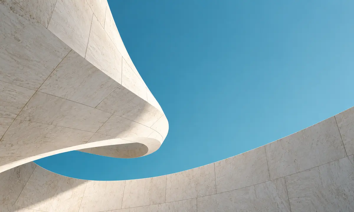 Curved pale stone architecture against a teal sky